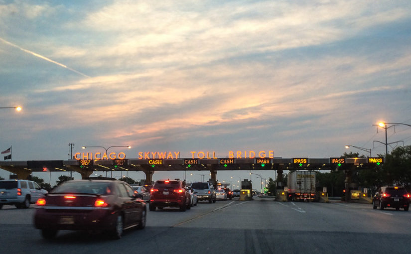 Cars line up as we approach the Chicago Skyway toll plaza on I-90 near sunset.