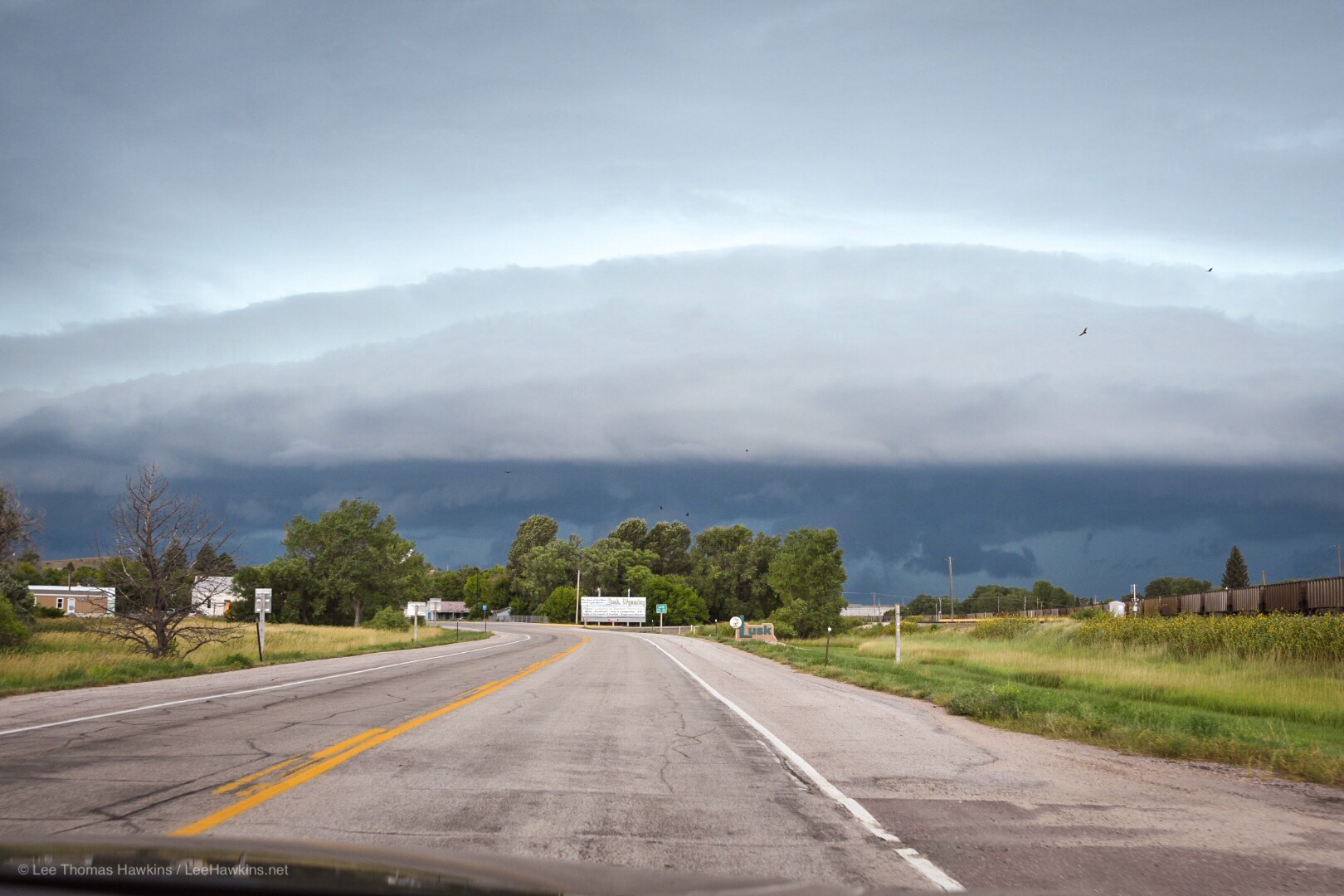 A giant heavy deep blue storm front approaches a city 