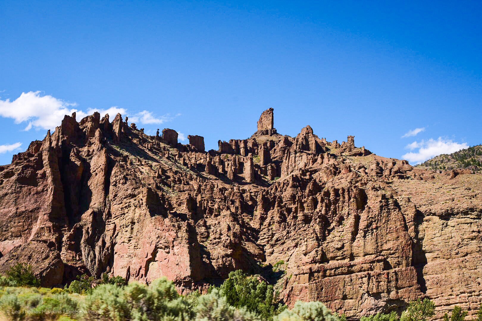 A jagged mountain rises up to a clear blue sky