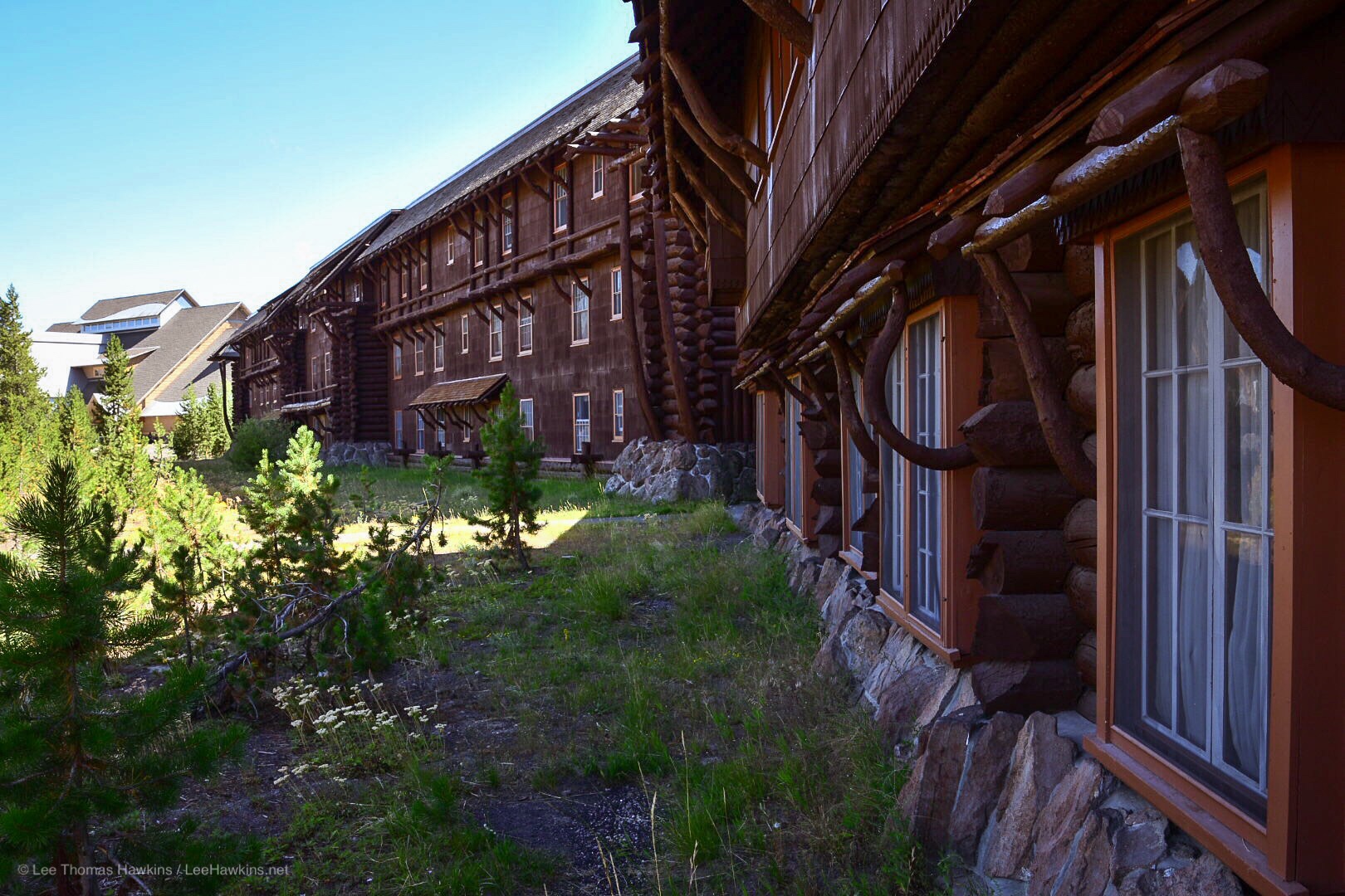 Bent logs form the many intricate details of a rustic wooden hotel building.